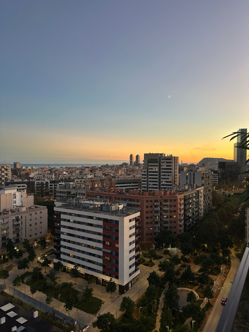 Behind the scenes: city skyline at sunset with a crescent moon