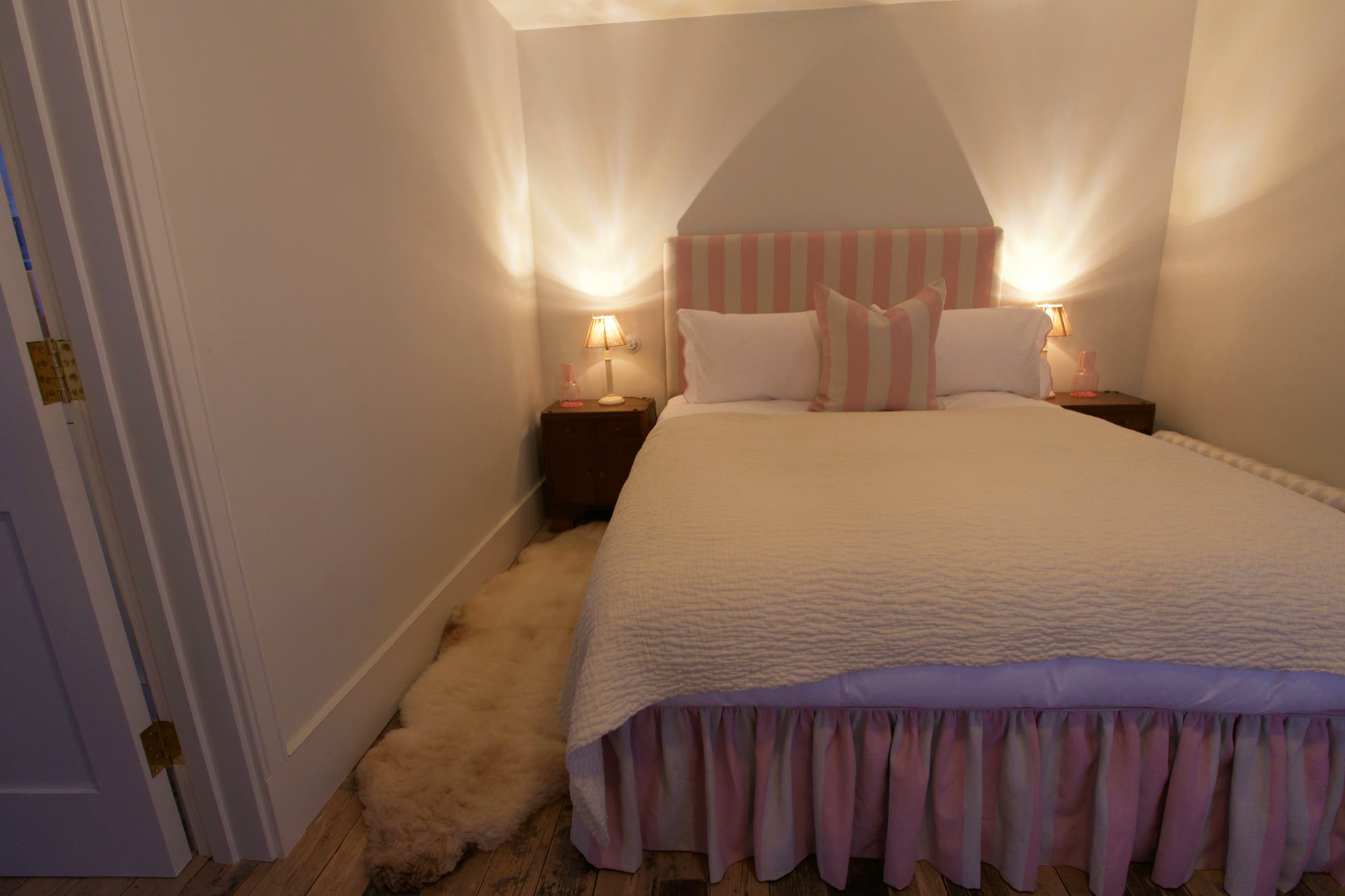 Bedroom with a striped headboard and warm bedside lamps