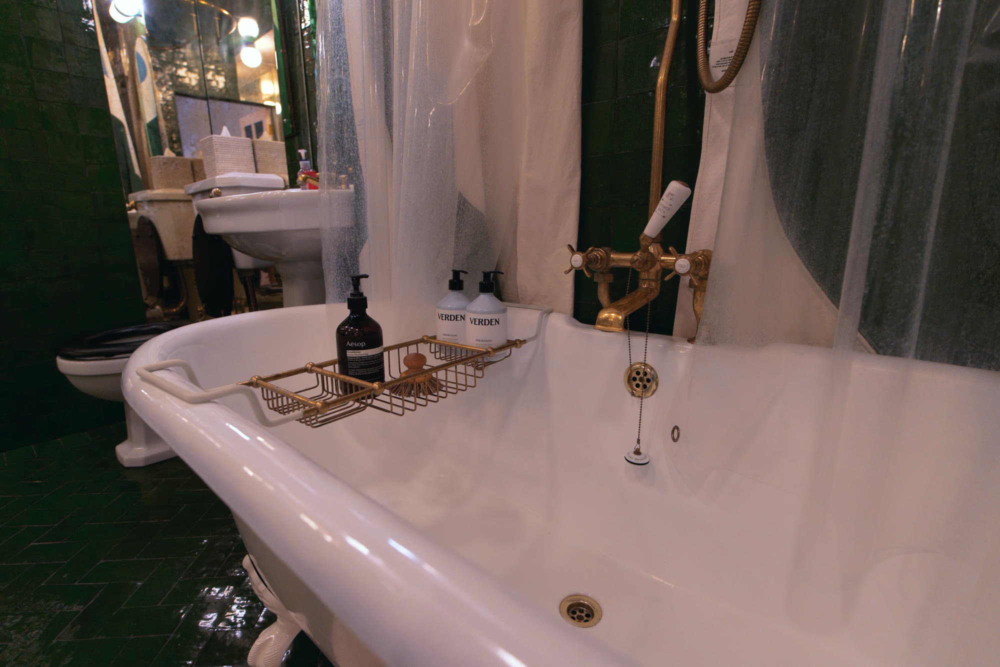 Clawfoot bath with brass fittings and a tray of toiletries