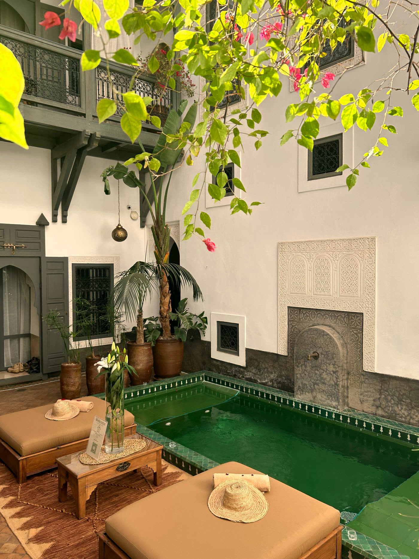 Riad courtyard with a green tiled pool and bougainvillea